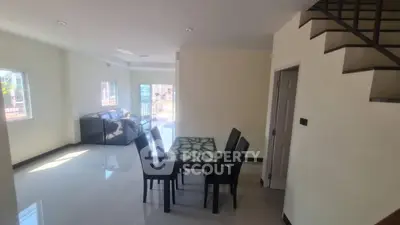 Spacious modern living room with dining area and staircase in bright natural light