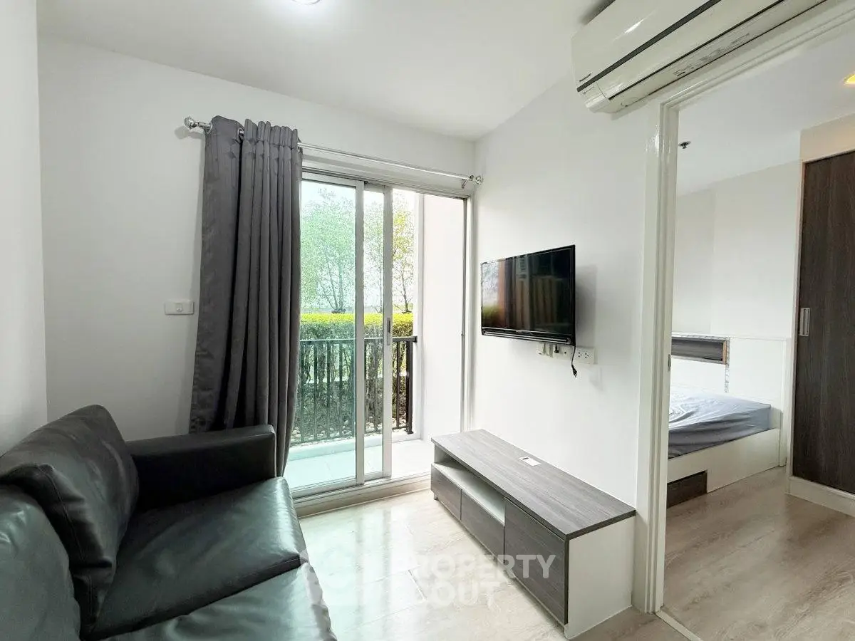 Modern living room with balcony access and sleek furnishings in a stylish apartment.