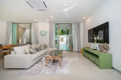 Spacious modern living room with pool view, elegant decor, and ample natural light.