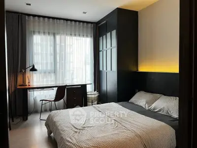 Modern bedroom with stylish decor and natural light, featuring a cozy bed and functional workspace.