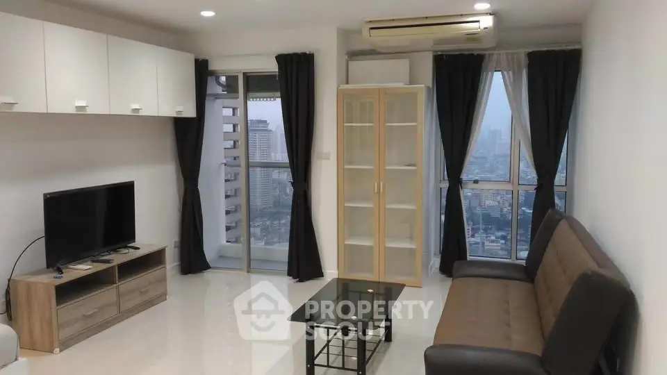 Modern living room with city view, featuring sleek furniture and large windows for natural light.