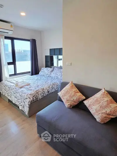Modern bedroom with cozy bed and stylish sofa in a bright apartment