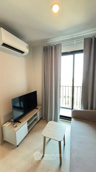 Modern living room with balcony view, featuring sleek furniture and natural light.