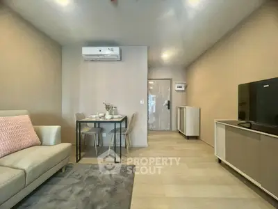 Modern living room with cozy sofa, dining area, and sleek TV setup