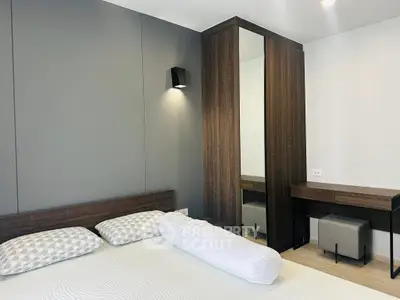 Modern bedroom with sleek design, featuring a stylish wardrobe and cozy bed setup.
