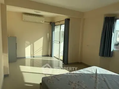 Spacious bedroom with natural light and balcony access
