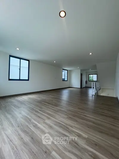 Spacious modern living room with sleek flooring and ample natural light