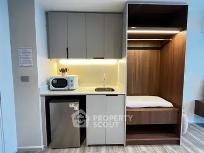 Modern compact kitchen with integrated appliances and cozy sleeping nook