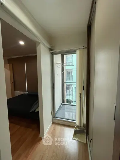 Cozy apartment with small balcony and wooden flooring, ideal for urban living.