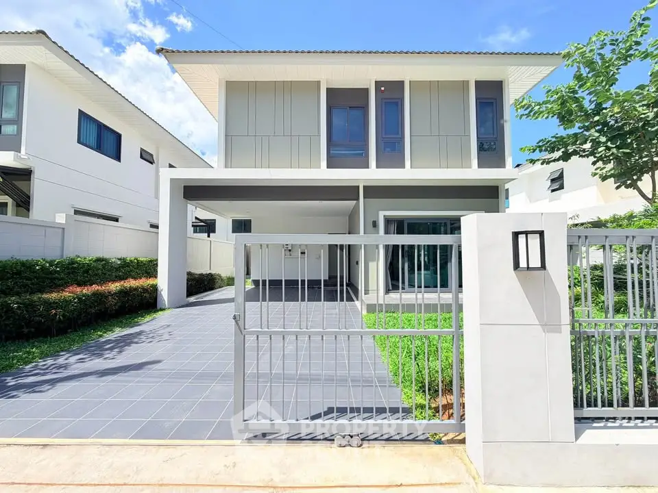 Modern two-story house with sleek design and spacious driveway in a serene neighborhood.