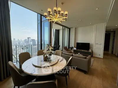 Luxurious living room with city view, elegant chandelier, and modern furnishings in high-rise apartment.