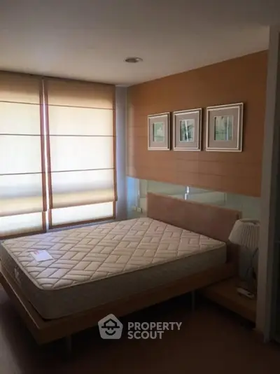 Cozy bedroom with modern decor and natural light, featuring a comfortable bed and stylish wall art.