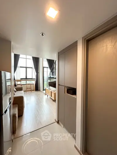 Modern living room with high ceilings and large windows, featuring stylish furniture and natural light.