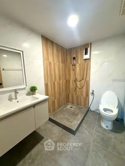 Modern bathroom with sleek design, featuring a spacious shower area and contemporary fixtures.