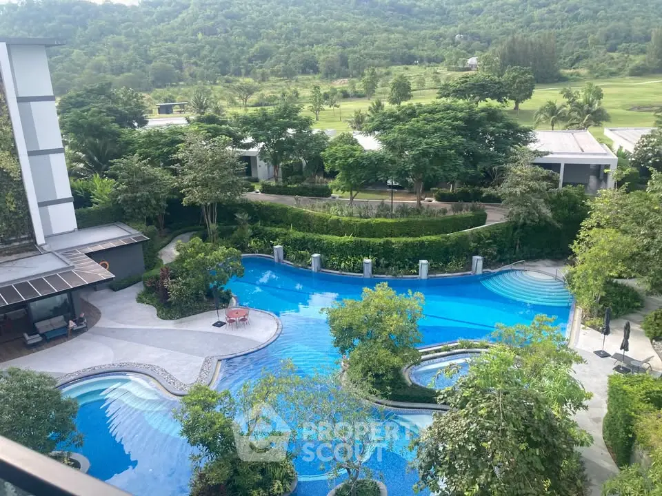 Luxurious resort-style pool with lush greenery and scenic views, perfect for relaxation and leisure.