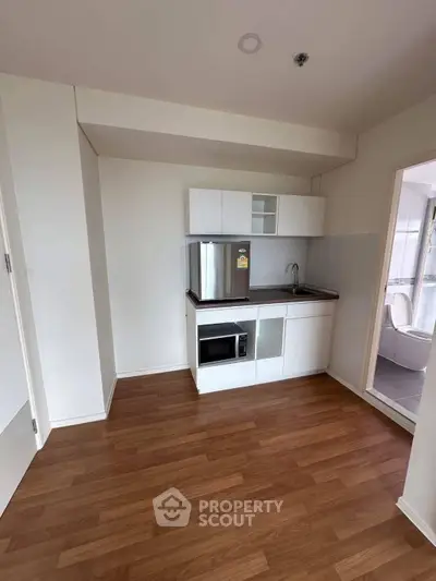 Compact kitchen with modern appliances and wooden flooring in a cozy apartment