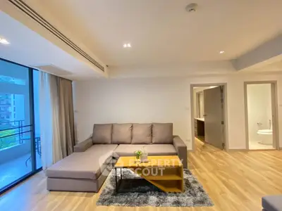 Spacious living room with modern decor and large windows in a stylish apartment.