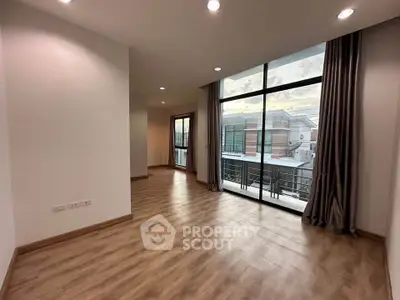 Spacious modern living room with large windows and wooden flooring