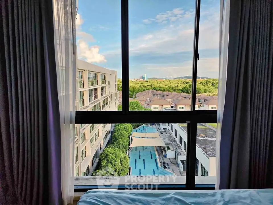 Stunning view from bedroom window overlooking pool and lush greenery