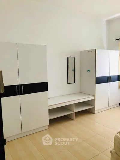 Spacious bedroom with modern white wardrobes and sleek design