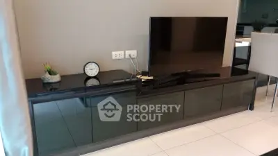 Modern living room with sleek TV stand and flat-screen TV, showcasing contemporary interior design.