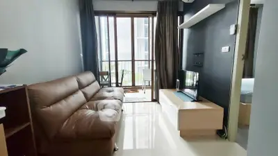 Modern living room with sleek furniture and balcony view in a stylish apartment.
