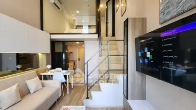 Modern loft-style living room with mezzanine, sleek furniture, and large TV, perfect for urban living.