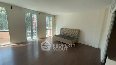 Spacious empty living room with large windows and hardwood floors