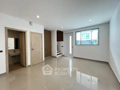 Spacious modern living room with sleek tile flooring and ample natural light.