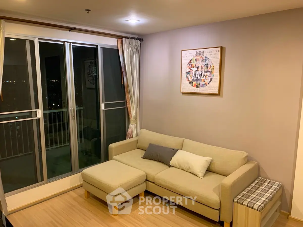 Cozy living room with beige sofa and balcony access in modern apartment