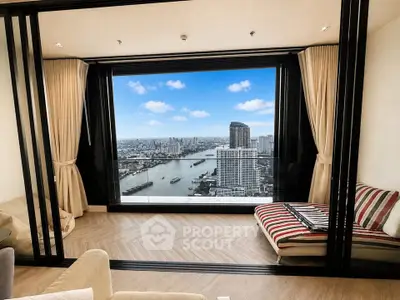 Luxurious living room with stunning city and river view from high-rise apartment.