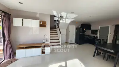 Spacious modern living room with open kitchen and staircase