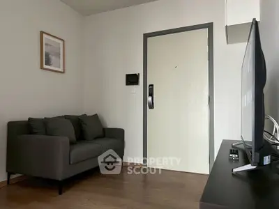 Cozy living room with modern sofa and wall-mounted TV, perfect for relaxation.