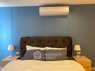 Cozy bedroom with plush headboard and modern air conditioning unit