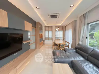 Modern living room with sleek furniture and large windows offering natural light.