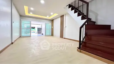 Spacious modern living room with staircase and sliding glass doors
