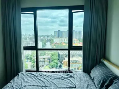 Stunning city view from a cozy bedroom with large window and modern decor.