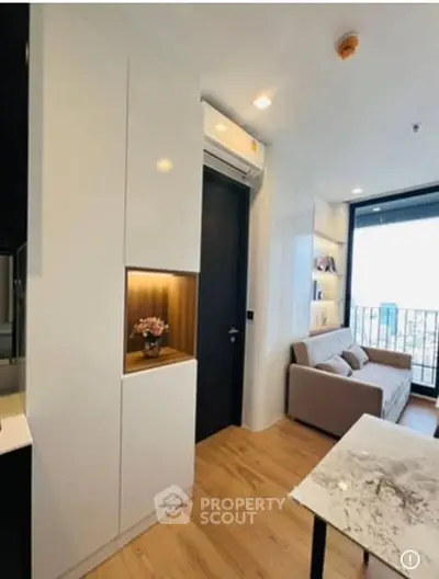 Modern living room with sleek design and balcony view in a stylish apartment.