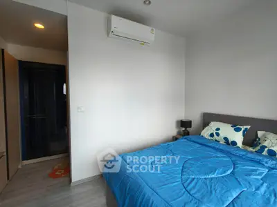 Modern bedroom with air conditioning and stylish blue bedding in a cozy apartment.