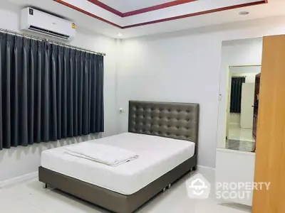 Modern bedroom with stylish bed and air conditioning in a cozy apartment.