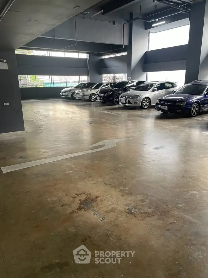 Spacious indoor parking area with multiple cars in a modern building.