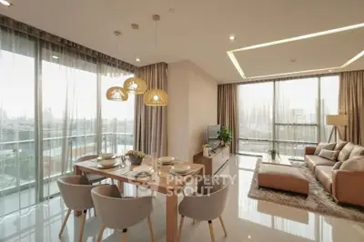 Luxurious modern living room with dining area, large windows, and elegant decor in a high-rise apartment.