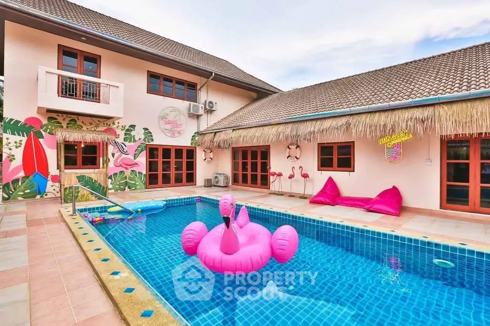 Vibrant tropical-themed poolside with flamingo float and colorful decor, perfect for relaxation and entertainment.