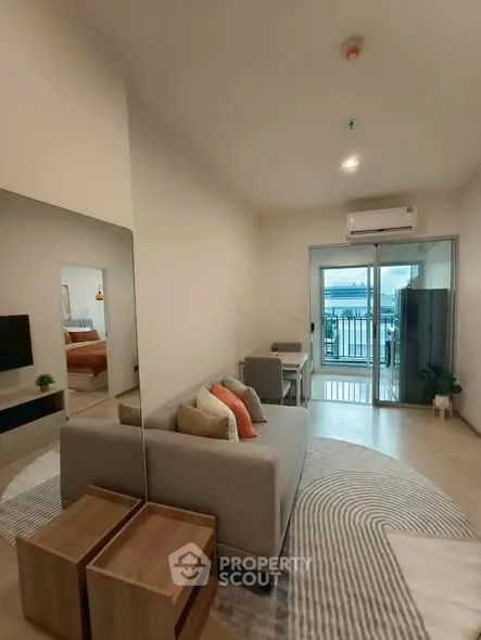 Modern living room with balcony and stunning view, featuring cozy seating and stylish decor.