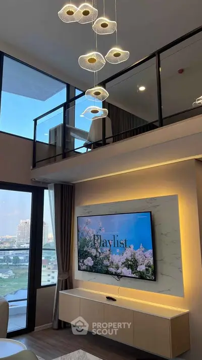 Luxurious modern living room with high ceiling, elegant chandelier, and large TV, offering stunning city views.