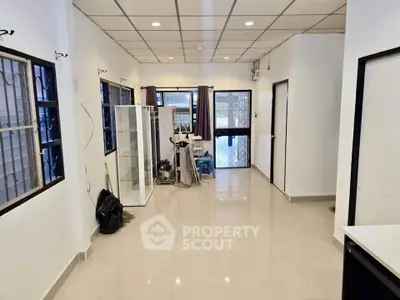 Spacious interior with tiled flooring and large windows, ideal for versatile living space.