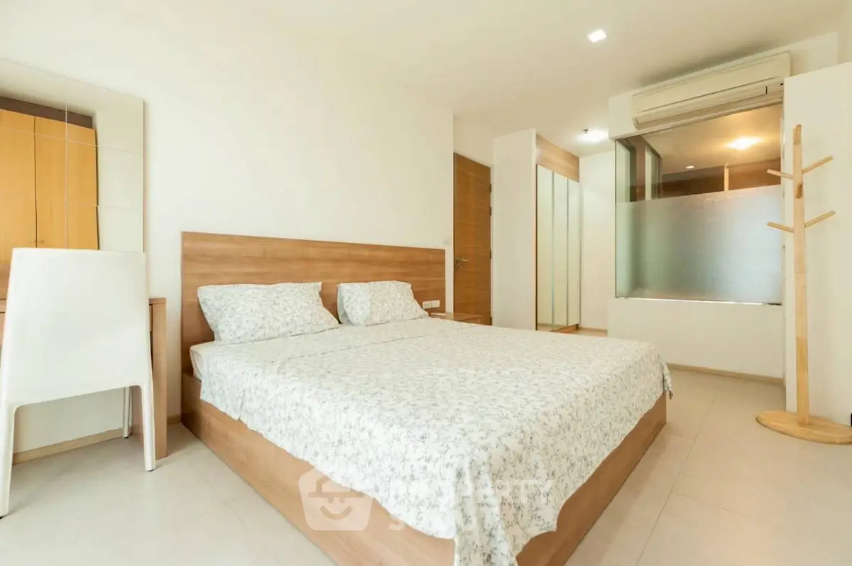 Spacious modern bedroom with minimalist design and ample natural light.