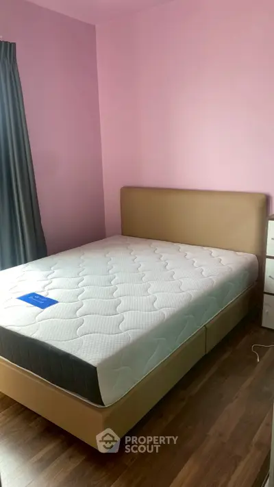 Cozy bedroom with pink walls and a comfortable bed, perfect for relaxation.