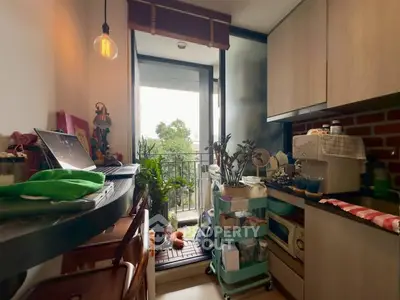 Cozy kitchen with open layout and small balcony, featuring modern appliances and natural light.