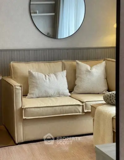 Cozy living room with beige sofa and decorative pillows, perfect for relaxation.